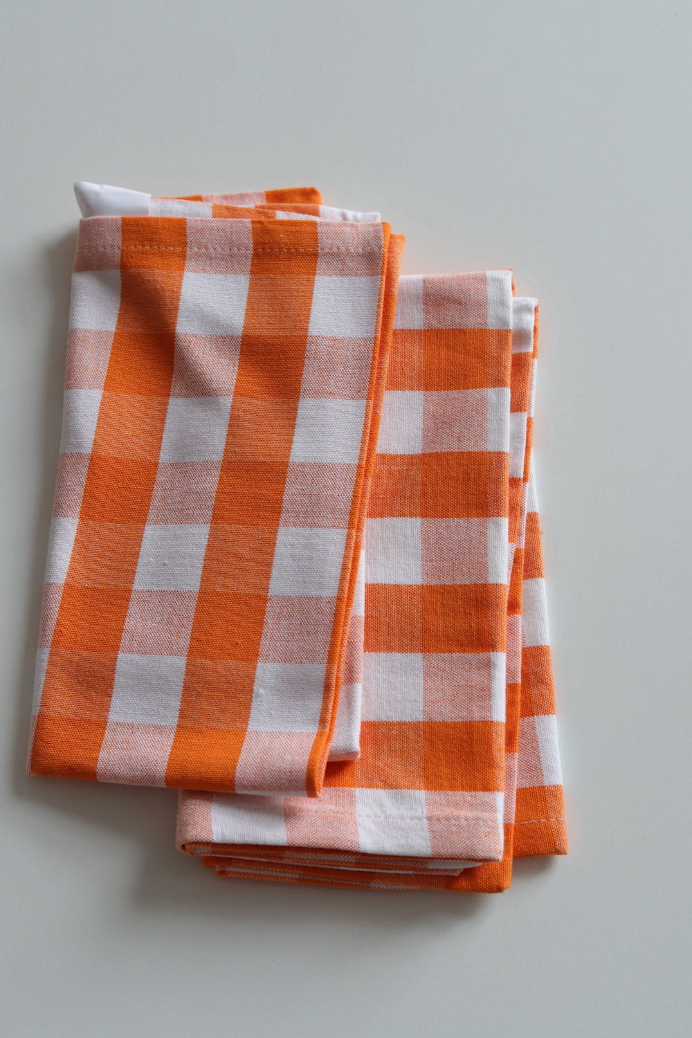 Two orange and white checked napkins