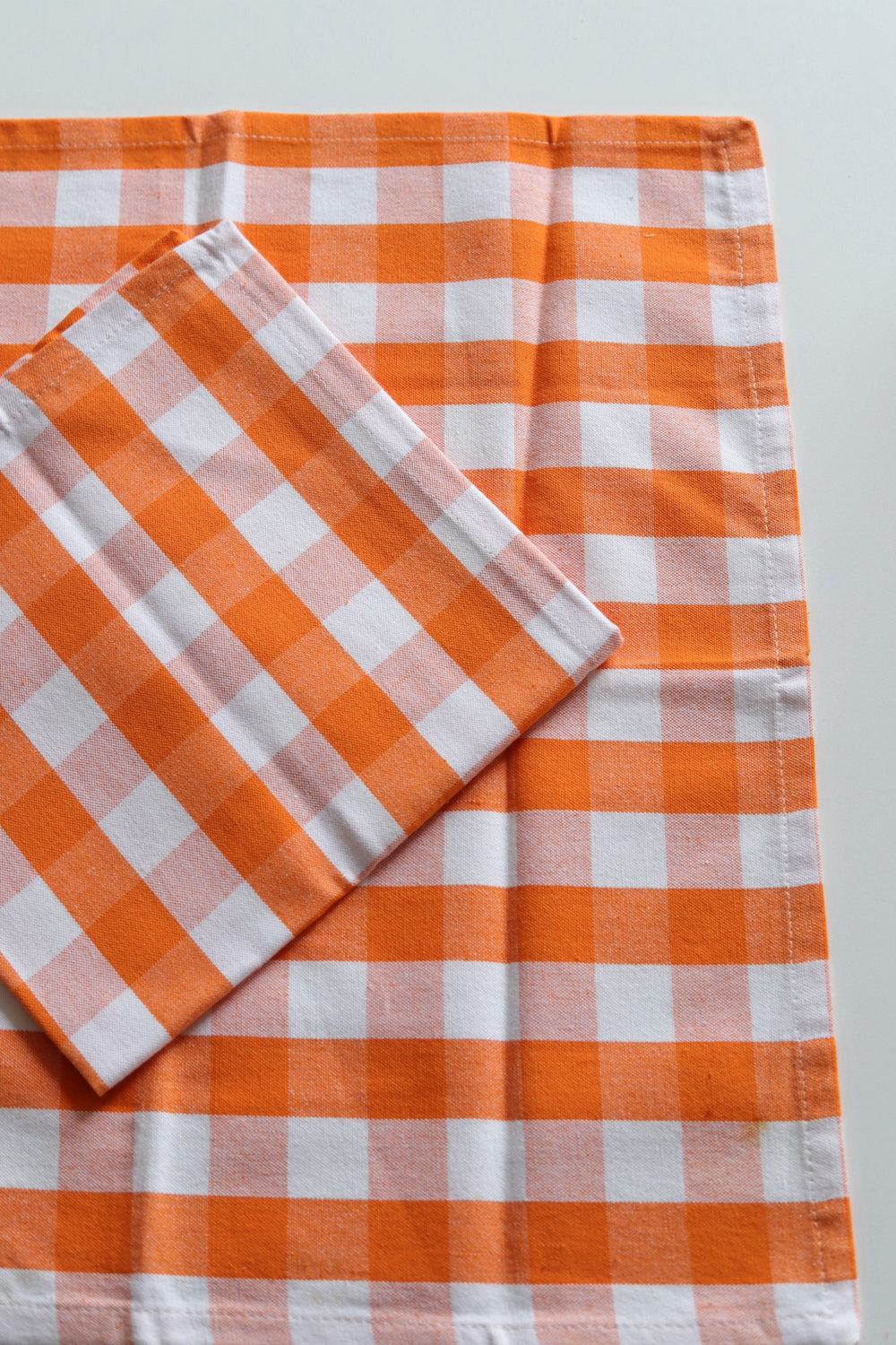 Two orange and white checked napkins