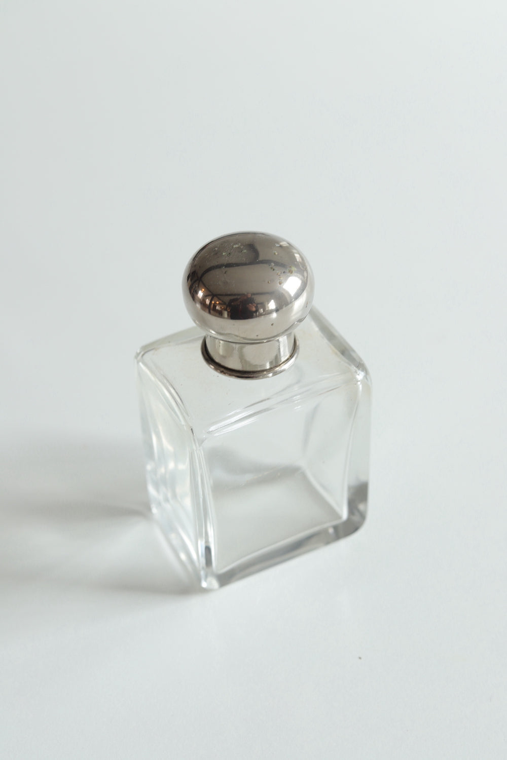 Vintage perfume bottle with original glass stopper and silver screw cap